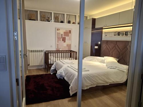 een slaapkamer met een bed met witte lakens bij Janela do Minho in Caminha