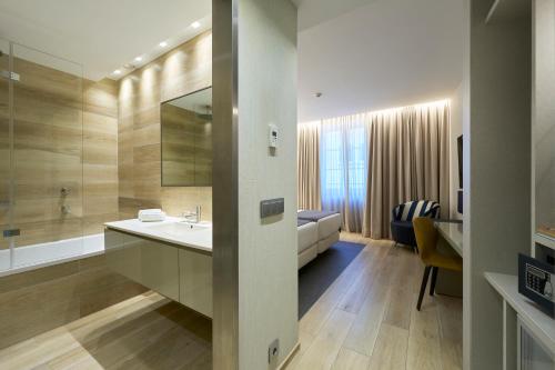 a bathroom with a sink and a bath tub at Catalonia Porto in Porto
