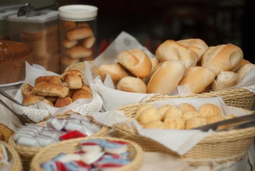 a bunch of baskets filled with different types of bread at Mariano Palace Hotel in Campinas