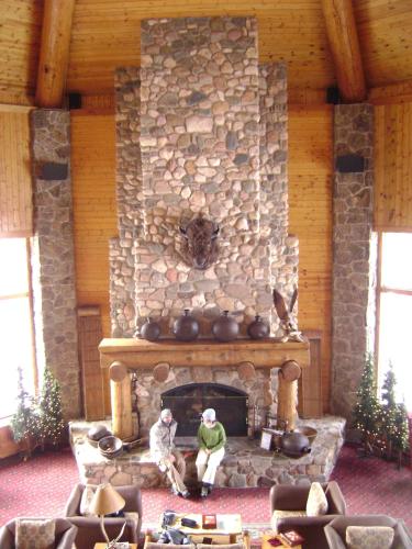 two men sitting in front of a stone fireplace at Spearfish Canyon Lodge in Spearfish