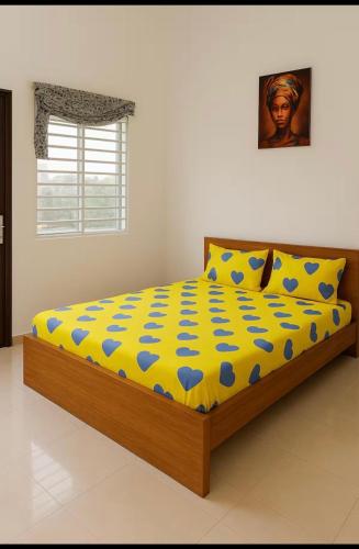 a bedroom with a bed with a yellow and blue comforter at Cozy II Studio with AC and kitchen in Abomey-Calavi