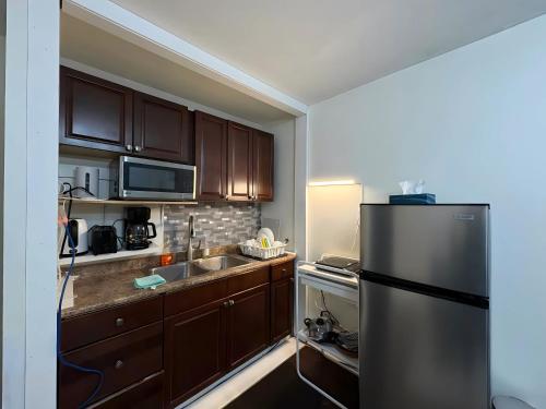 een keuken met houten kasten en een roestvrijstalen koelkast bij Chapman H in Toronto