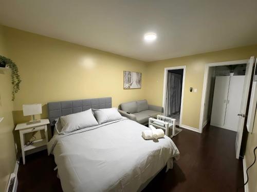 a bedroom with a large white bed and a couch at Chapman H in Toronto