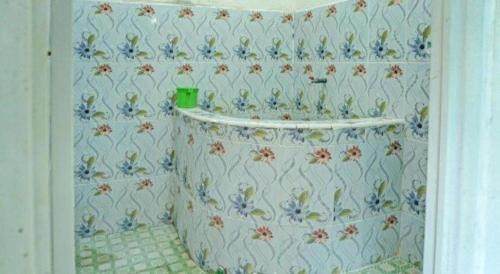 a bathroom with a floral patterned wall at Hotel O Penginapan Indola Near Masjid Al Muhtadin in Muaradua