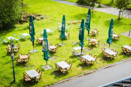 un gruppo di tavoli e sedie con ombrelloni di Oveney Apartments a Bochum