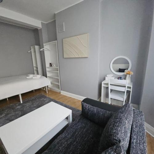 a living room with a couch and a mirror at Comfortable Private Rooms in Central London Next to Station in London