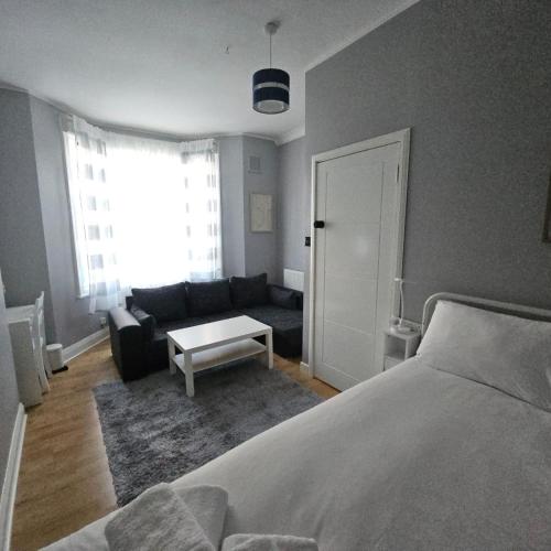 a bedroom with a bed and a living room at Comfortable Private Rooms in Central London Next to Station in London