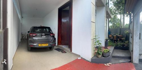 een auto staat geparkeerd buiten een garage bij A&J Rest House 