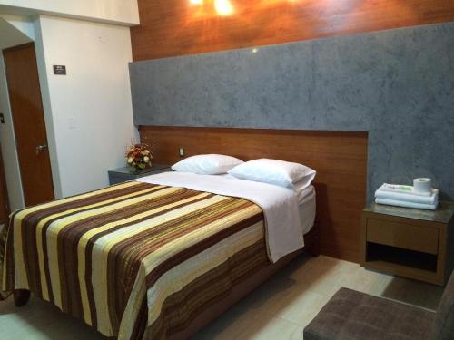 a bedroom with a large bed with a wooden headboard at Hostal Gold Star in Tacna