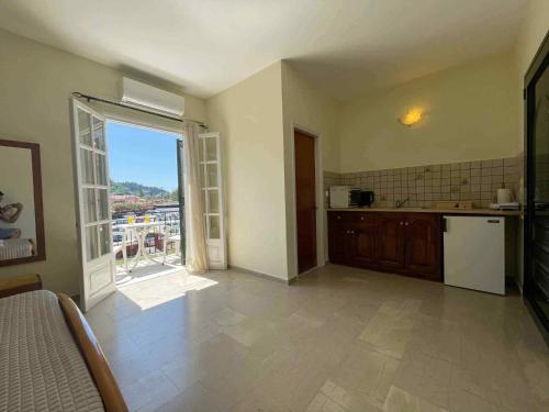 une cuisine avec une porte ouverte sur un balcon dans l'établissement Exclusive Alexandra Apartments, à Sidari