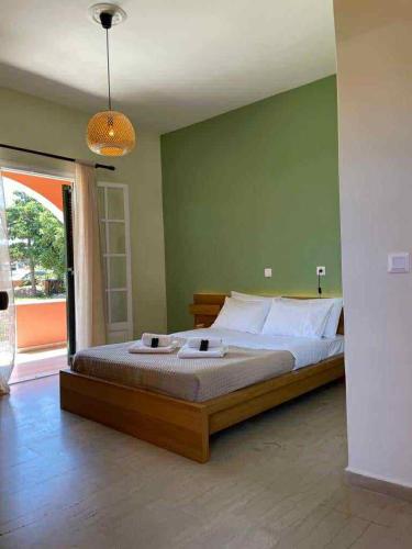 a bedroom with a large bed with a green wall at Exclusive Alexandra Apartments in Sidari