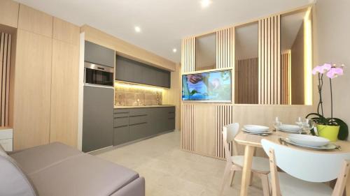a kitchen and living room with a table and a television at Studio du Soleil in Le Val