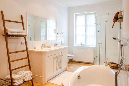 een badkamer met een bad, een wastafel en een douche bij Strömbergs Merle in Oberstaufen