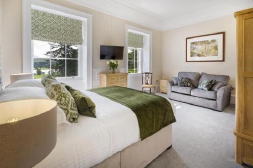 een slaapkamer met een groot bed en een bank bij 2 Bed in Soulby oc-d28926 in Pooley Bridge