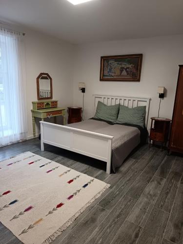 a bedroom with a bed and a mirror and a rug at Tornác Vendégház in Diszel