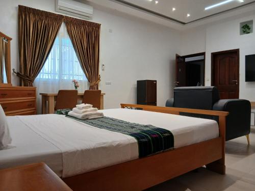 a bedroom with a bed and a table and chairs at Sheyllo Suites Abidjan - Cocody in Abidjan