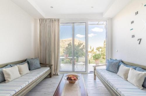 un soggiorno con un divano e una grande finestra di The Holiday House 1 a Kavrokhórion