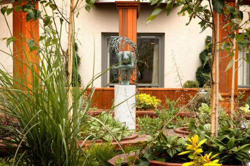 a garden with a statue in front of a house at Westport Plaza Hotel, Spa & Leisure in Westport