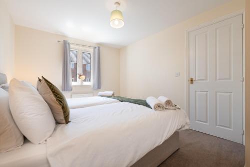 una camera da letto con un letto bianco con una finestra di Greatdown RnR Stays a Greenford