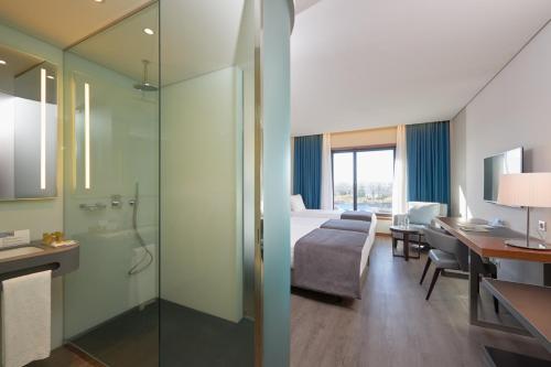 una camera d'albergo con un letto, una scrivania e un bagno di Timbre Heroismo a Porto