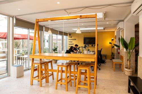 een restaurant met een grote houten tafel en krukken bij WOT Nomad Social in Lissabon