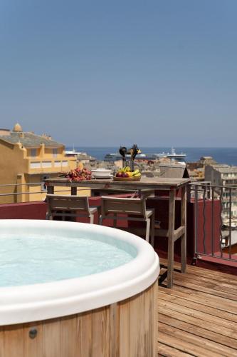 a hot tub on top of a balcony with a table at Vatta appartement centre ville avec roof top bain à remous et vue panoramique in Bastia