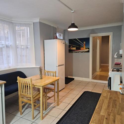 a kitchen and dining room with a table and a refrigerator at Comfortable Private Rooms in Central London Next to Station in London