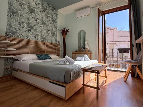 een slaapkamer met een bed en een groot raam bij Dolce Marea Suites in Licata