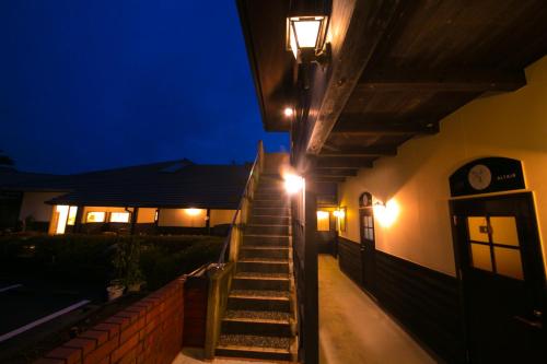 a staircase leading up to a house at night at Yufuin Bath Satoyamasafu in Yufu