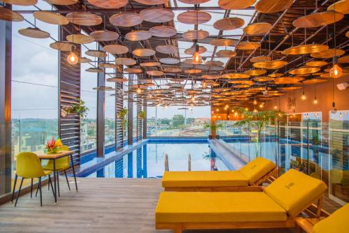 una piscina con un divano giallo e un tavolo di ART Residence a Porto-Novo