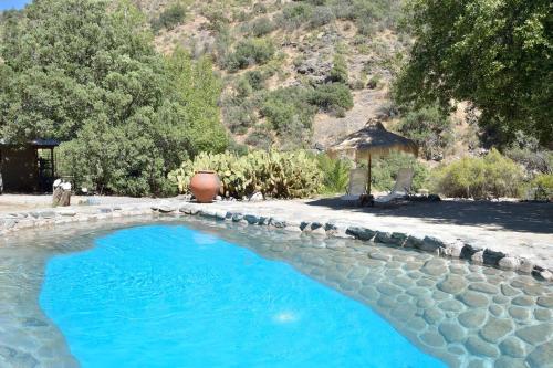 een zwembad in een tuin met een tuinhuisje bij El Cielo Lodge in San José de Maipo