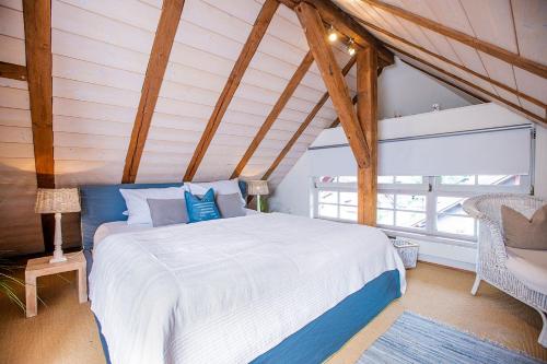 een slaapkamer met een wit bed en een stoel bij Strömbergs Gunnar in Oberstaufen