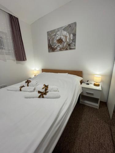 a bedroom with a white bed with towels on it at Apartmani MOSLAVINA i parking in Kutina