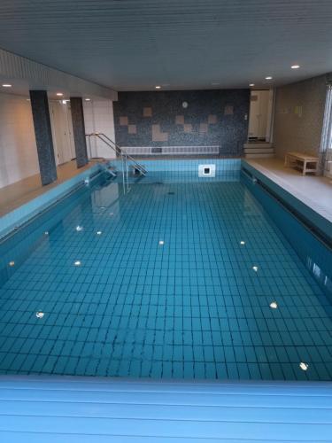 een groot zwembad met een tegelvloer en een zwembad bij Ferienwohnung in Schönwald