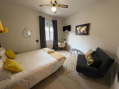 een slaapkamer met een bed en een stoel erin bij N1 L horizon d or in Paray-le-Monial