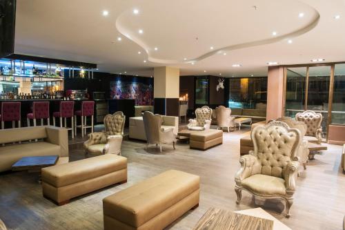 un vestíbulo con sofás y sillas y un bar en Hotel Grand Park, en Bogotá