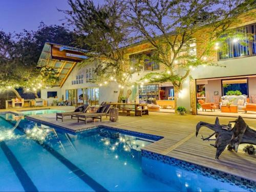 a home with a swimming pool and a house at Dombeya Private Game Reserve in Vaalwater