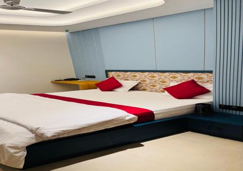 a bedroom with a large bed with red pillows at Hotel Royal Plaza in Phulabāni