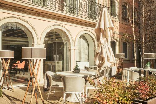 a patio with a table and chairs and an umbrella at Catalonia Porto in Porto