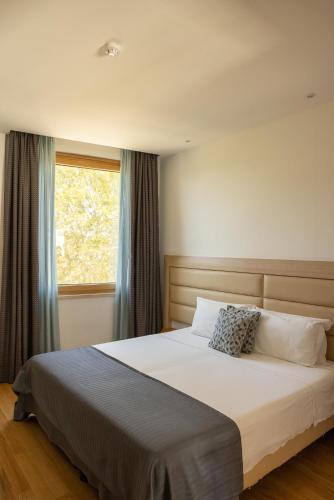 a bedroom with a large bed with a window at Palazzo Virgilio in Brindisi