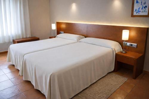 Una habitación de hotel con dos camas y dos lámparas. en Hotel Santuari Balaguer, en Balaguer