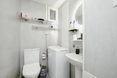 a white bathroom with a toilet and a sink at luxury house in Ierapetra