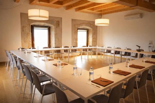 Una gran sala de conferencias con una mesa larga y sillas. en Hotel Santuari Balaguer, en Balaguer