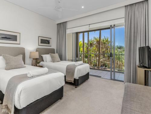a hotel room with two beds and a balcony at Bali Luxury Resort - Holiday Management in Kingscliff