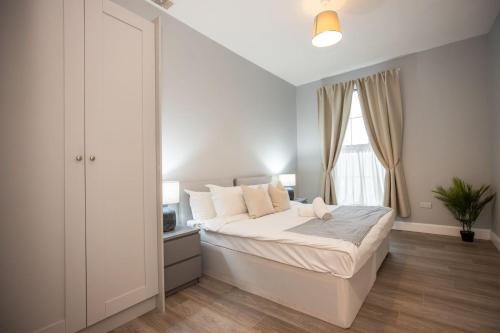 een witte slaapkamer met een bed en een raam bij Richmond Hill in Dublin