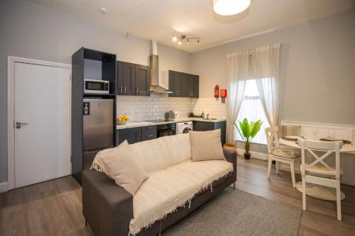 een woonkamer met een bank en een keuken bij Richmond Hill in Dublin