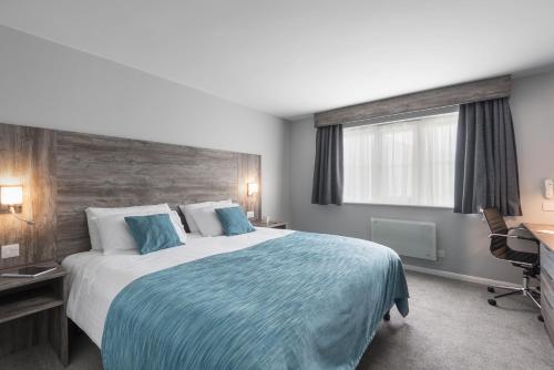 ein Schlafzimmer mit Bett, Schreibtisch und Fenster in der Unterkunft The Willows Training Centre in Saint Neots