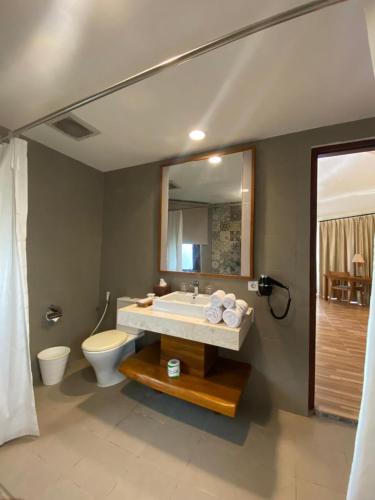 a bathroom with a sink and a toilet and a mirror at Marahai Villa Morotai in Dehegila