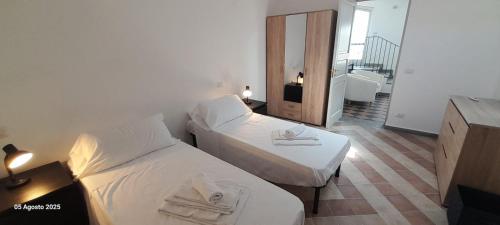 una camera d'albergo con due letti e un bagno di La Terrazza a Patti
