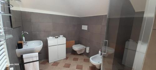 un piccolo bagno con un water e un lavandino di La Terrazza a Patti